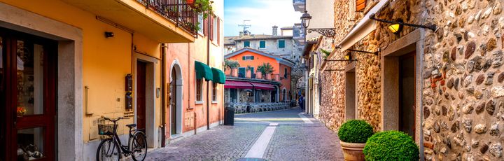 Eine enge Gasse mit Gebäuden und Pflanzen.