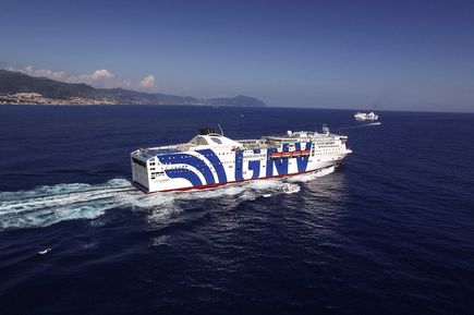 Kreuzfahrtschiff fährt durch das Meer mit Berg im Hintergrund