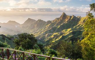 Eine Küstenlandschaft mit einem Strand, Bergen und einer Stadt.