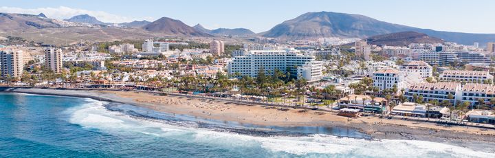 Blick aus der Vogelperspektive auf den Strand und das Hinterland mit seinem Häusern und Hotels in Playa de las Americas.