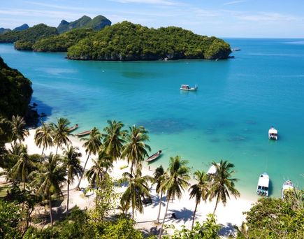 Eine malerische Bucht im Ang Thong Nationalpark in Thailand, mit steilen, bewaldeten Inseln, die aus dem türkisfarbenen Meer ragen.