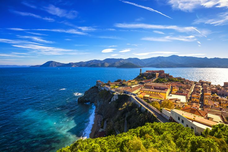 Panoramablick auf Portoferraio auf Elba mit der Festung, dem Hafen und dem klaren blauen Meer unter strahlendem Himmel.