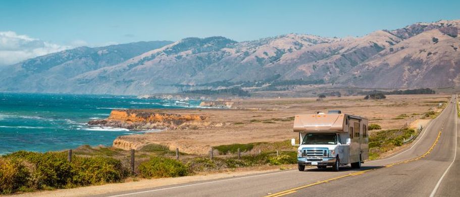Ein Bus, der zu einem Wohnmobil umgebaut wurde, steht auf einem Parkplatz mit Blick auf den Pazifischen Ozean in Big Sur, Kalifornien.