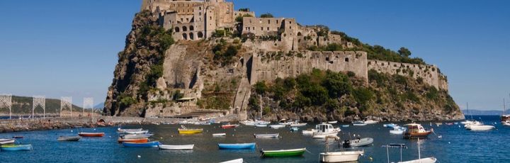 Eine Festung auf einer Insel mit Blick auf das Meer und Boote.