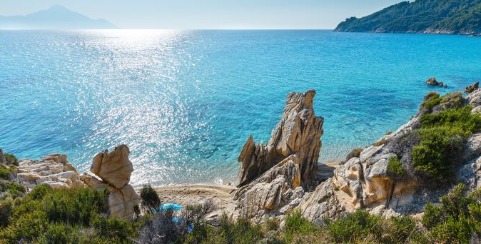 Eine Stadtansicht mit Gebäuden auf einem Hügel und Blick auf das Meer.