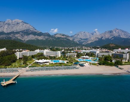Blick vom Meer aus auf Kemer; den Strand und die dahinterliegenden Hotels und Berge. Blauer Himmel