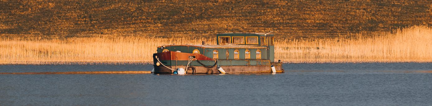 altes HAusboot auf einem Fluß