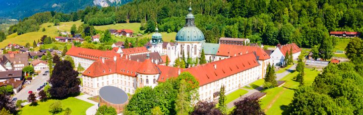 Blick auf das imposante Kloster Ettal bei sonnigem Wetter.
