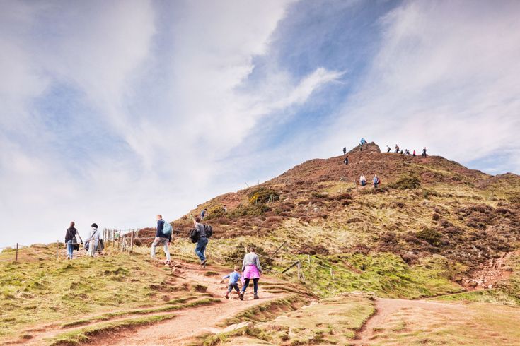 Zwei Personen wandern auf einem Hügel.