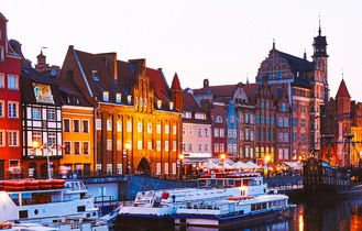 Eine Altstadt in Danzig, Polen, mit bunten Häusern am Kanal und Booten.