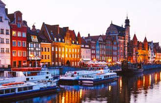Eine Altstadt in Danzig, Polen, mit bunten Häusern am Kanal und Booten.