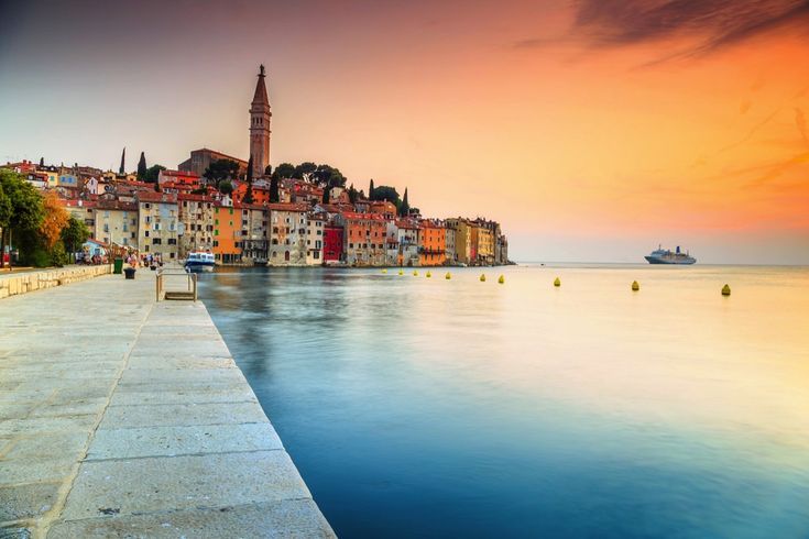 Eine Luftaufnahme der Stadt Rovinj, Kroatien, mit roten Dächern und dem Meer bei Sonnenuntergang.