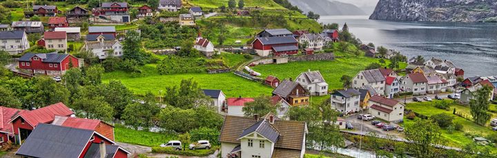 Blick über Sognefjord am Hang mit Wohnhäusern.