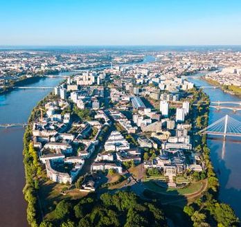 Eine Luftaufnahme einer Stadt mit einem Fluss und einem Schloss.