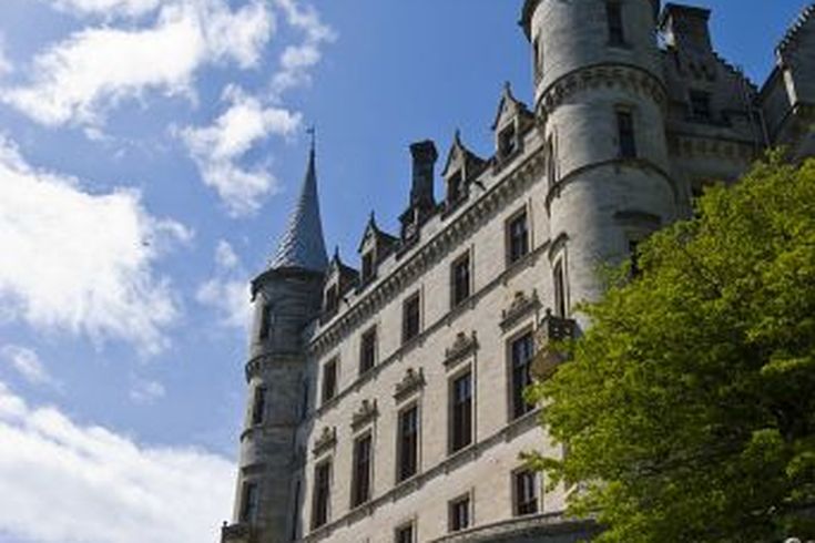 Eine historische Architektur mit einem Schloss und einem Turm. Die Gebäude sind aus Stein und wirken alt.