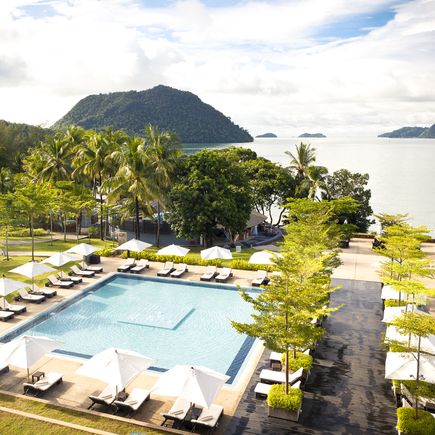 Exklusive Hotelanlage an der Küste mit Pool im Schatten der Palmen