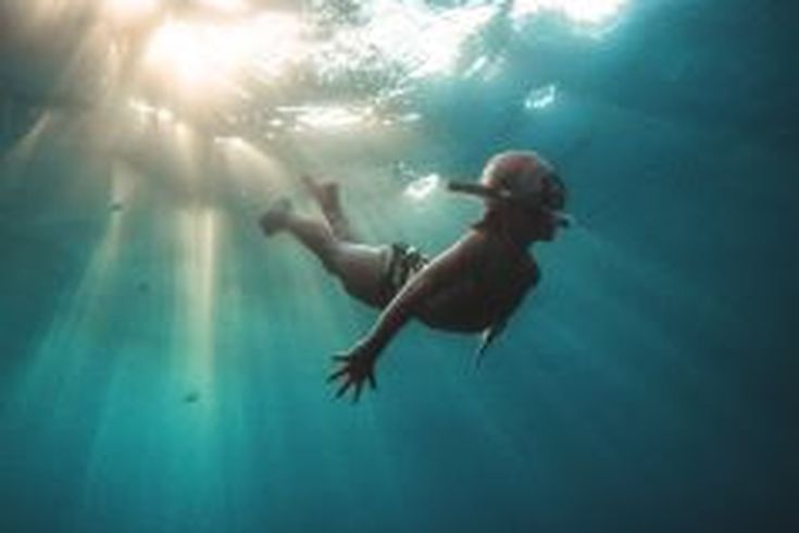 Ein Kind taucht unter Wasser.