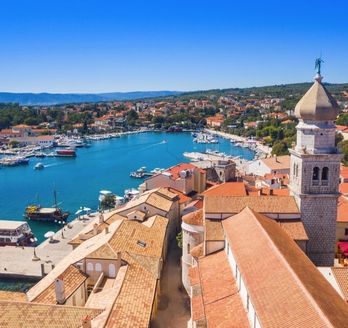 Die Altstadt von Krk, Kroatien, mit roten Dächern und einem Kirchturm.