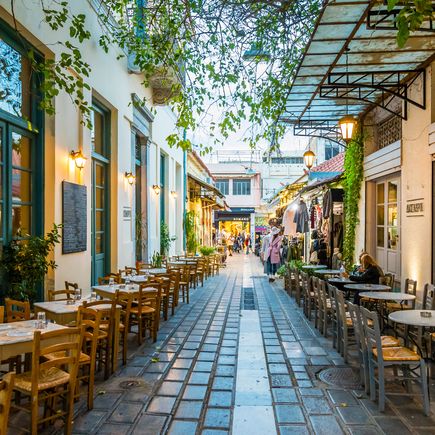 Eine kleine Gasse mit Außentischen in Athen.