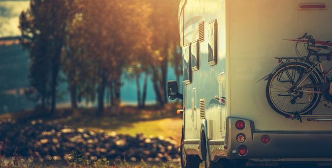Ein Wohnmobil auf einer Straße bei Sonnenuntergang.
