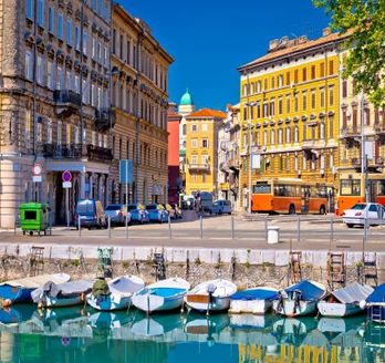Eine Stadtansicht mit Gebäuden, die sich im Wasser spiegeln, und Booten.