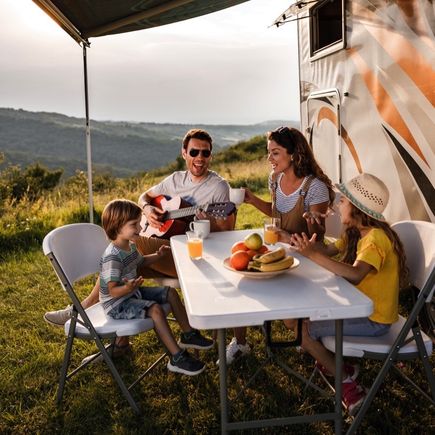 Familienfruehstueck vor dem Camper