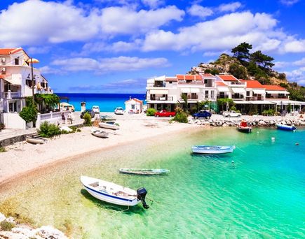 Eine Küstenstadt mit einem Strand und türkisfarbenem Wasser.