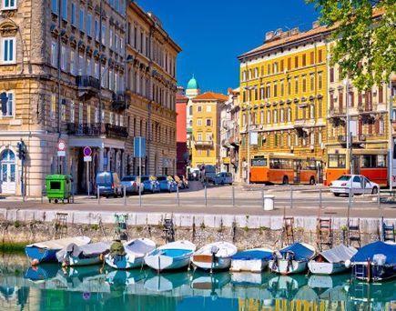 Eine Stadtansicht mit Gebäuden, die sich im Wasser spiegeln, und Booten.