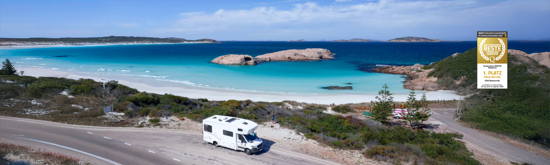 Camper steht an einer Küstenstraße in Australien am hellblauen Meer 