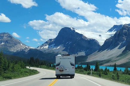 Camper fährt entlang einer Straße neben einem See in Kanada