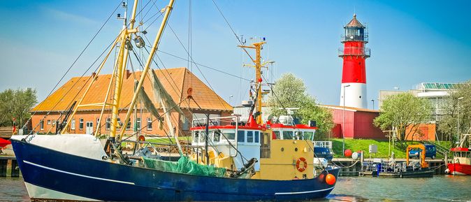 Urlaub an der Nordsee Büsum Fischerboot und Leuchtturm