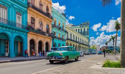 Grüner Oldtimer fährt auf der Hauptstraße in Havanna Stadt Kuba an der historischen Häuserfront vorbei