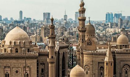 Eine Panoramansicht der Zitadelle von Kairo, mit mehreren großen Moscheen und Minaretten, die sich vor der modernen Skyline der Stadt abzeichnen.