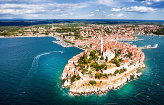 Eine Luftaufnahme einer Küstenstadt mit einer Insel und dem Meer.