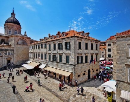 Eine historische Straße in Dubrovnik mit alten Gebäuden und Menschen.