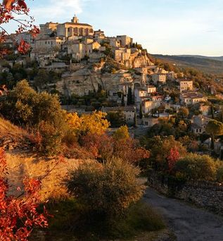 Eine Landschaft mit Bäumen in Herbstfarben und einem Fluss.