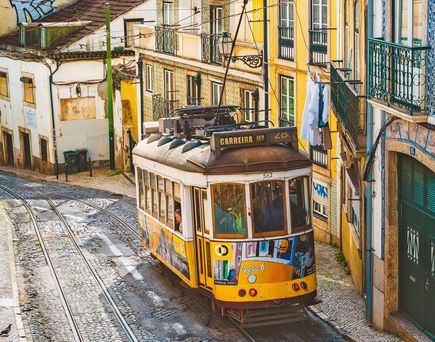Tram in Lissabon, Portugal fährt zwischen bunten Häusern