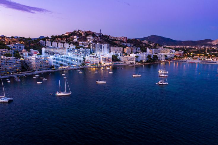 Blick auf den kleinen Hafen von Costa Calma. Einige Botte im Wasser, kleiner Strandabschnitt und dahinter Hotels und Gebäude.