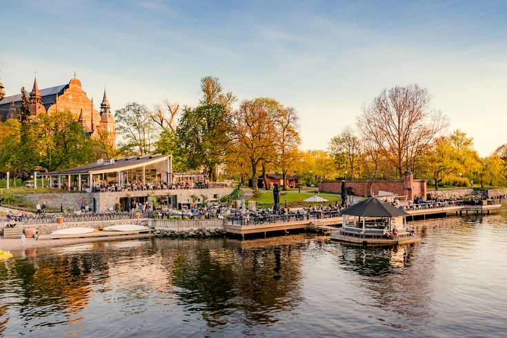 Eine Stadtansicht mit Gebäuden und einem Fluss, umgeben von Herbstbäumen.
