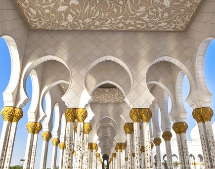 Ein Innenraum mit hohen Bögen und Säulen in einem arabischen Stil.