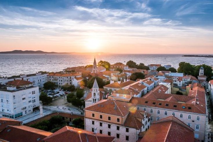 Eine Stadtansicht von Zadar, Kroatien, bei Sonnenuntergang mit roten Dächern.