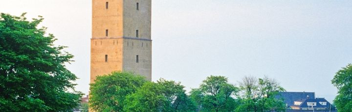 Ein Turm auf einem Hügel mit einem roten Dach.