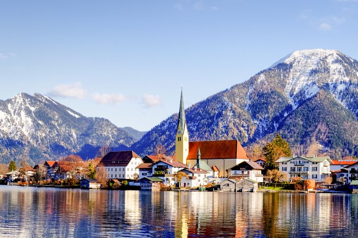 Eine Stadt am Ufer eines Sees, umgeben von schneebedeckten Bergen, Bayern. Tegernsee.