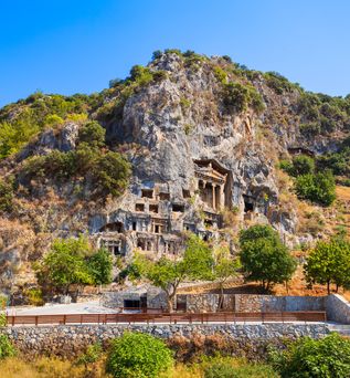 Die antiken Felsengräber von Amyntas in Lykien, Türkei, kunstvoll in eine bewachsene Bergwand gehauen.