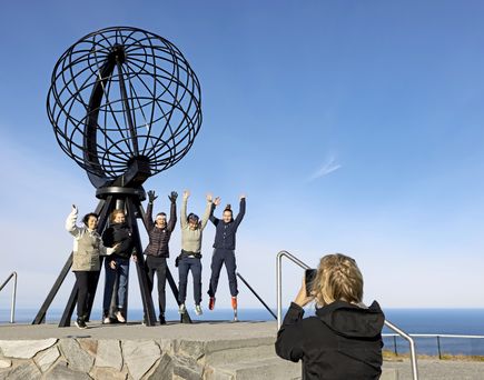 Menschen vor dem Globus am Nordkap machen ein Foto