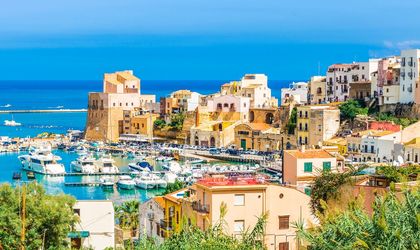 Eine Küstenstadt mit roten Dächern und Blick auf das Meer.