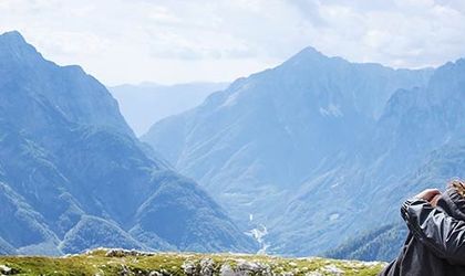 Ein Bergpfad schlängelt sich durch eine schneebedeckte Landschaft in den Schweizer Alpen, umgeben von majestätischen Gipfeln und einem klaren blauen Himmel