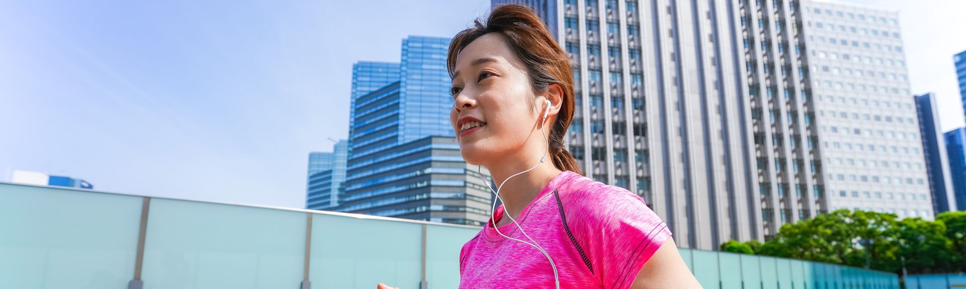 Joggende Frau im pinken Shirt läuft durch Tokyo