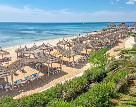 Strand von Hammamet. Liegen und Schirme aus Bast, glasklares blaues Meer und blauer Himmel