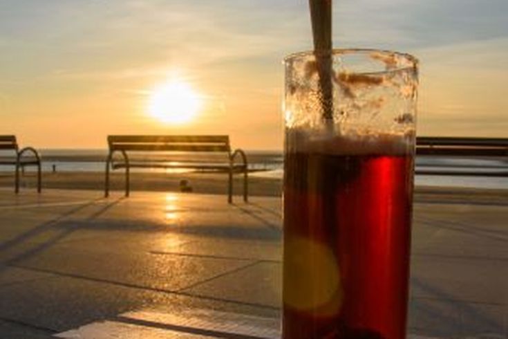 Ein Getränk am Strand bei Sonnenuntergang.